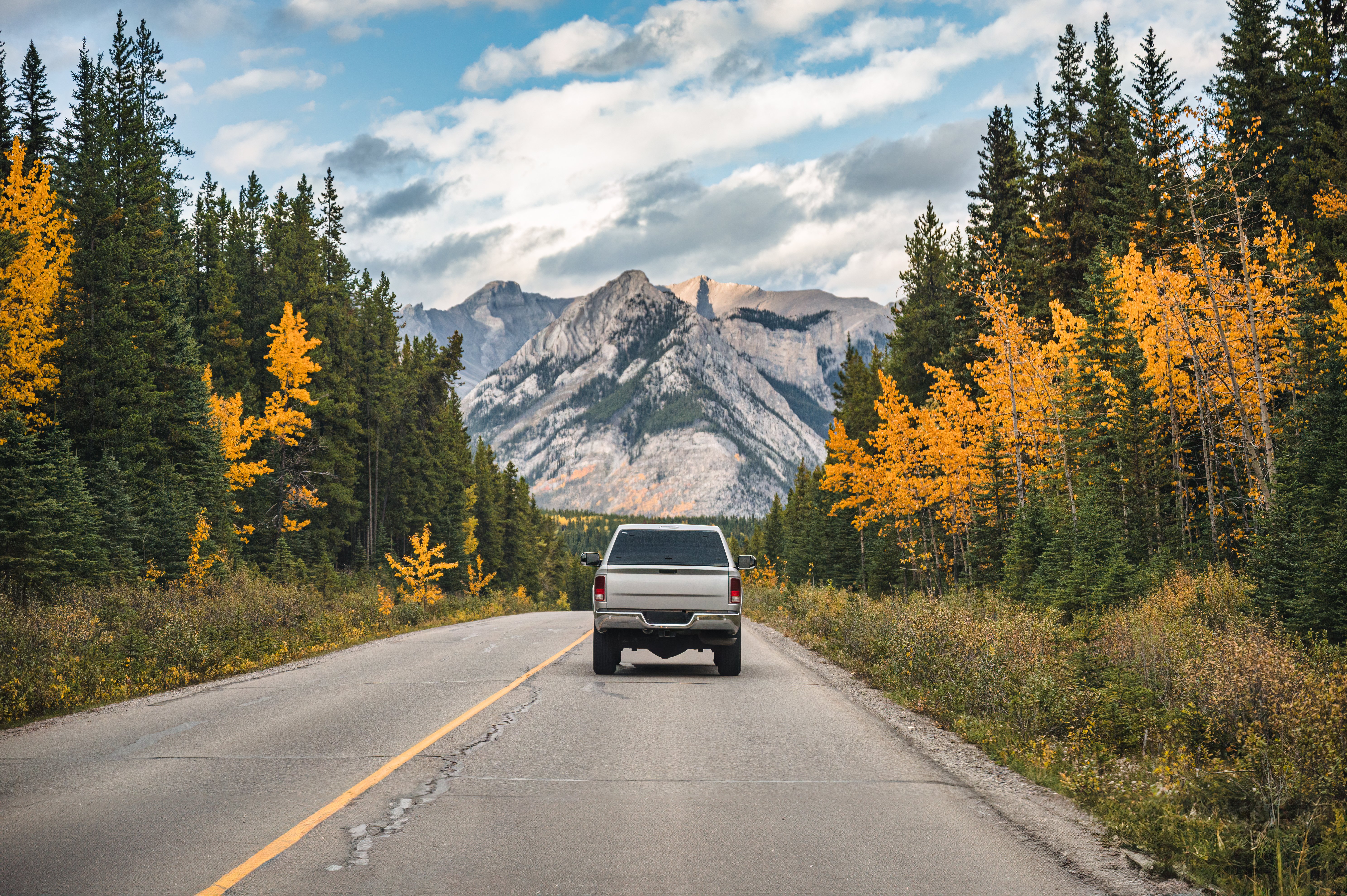 pickup-truck-driving-on-highway-in-autumn-forest-a-2024-07-29-19-15-15-utc